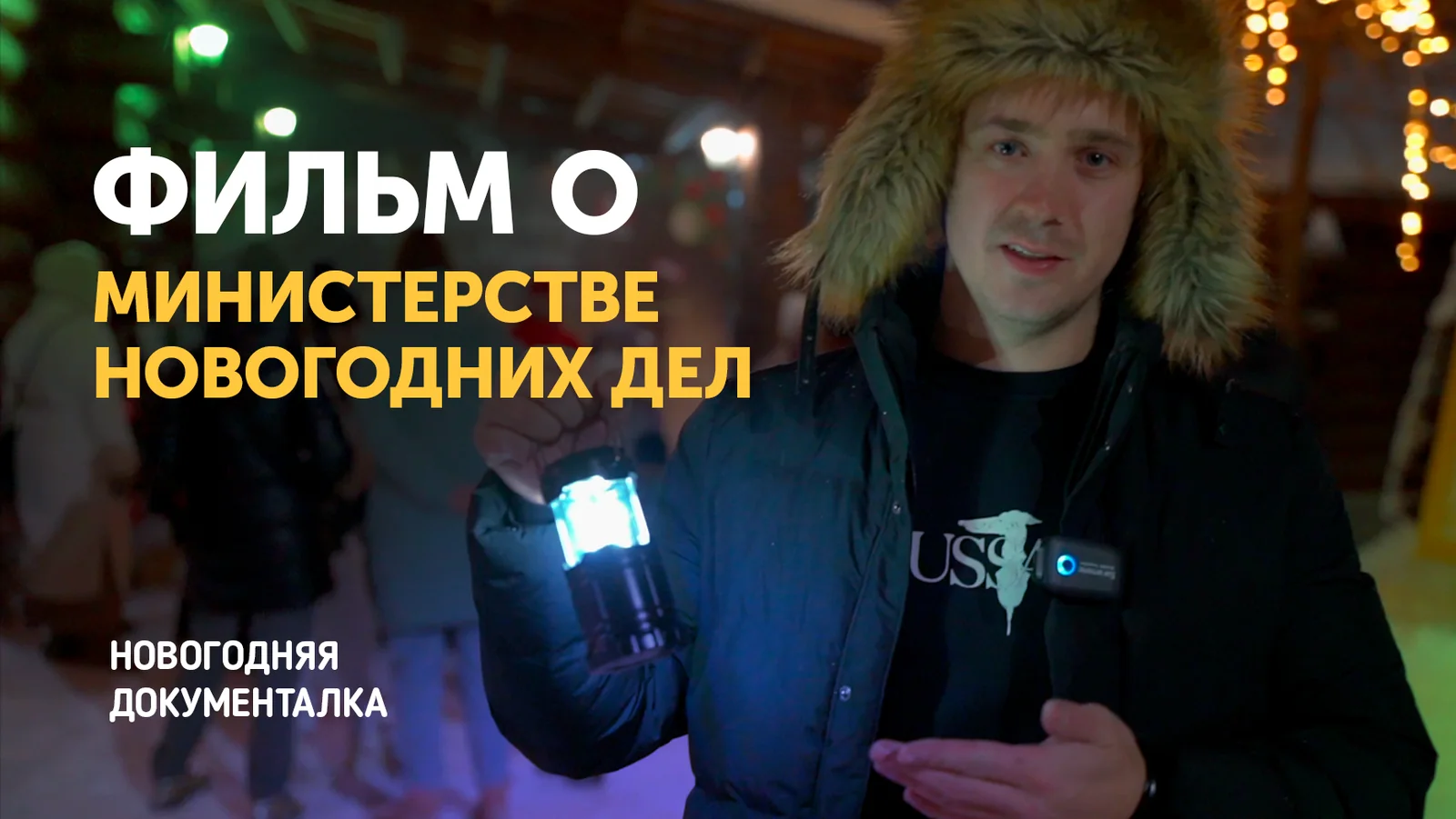 Ведущий с фонарём во дворе площадки, надпись «Фильм о Министерстве Новогодних Дел, новогодняя документалка»
