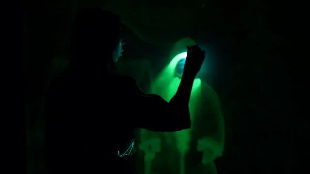 Светящийся зелёный рисунок в темноте на шоу рисования светом